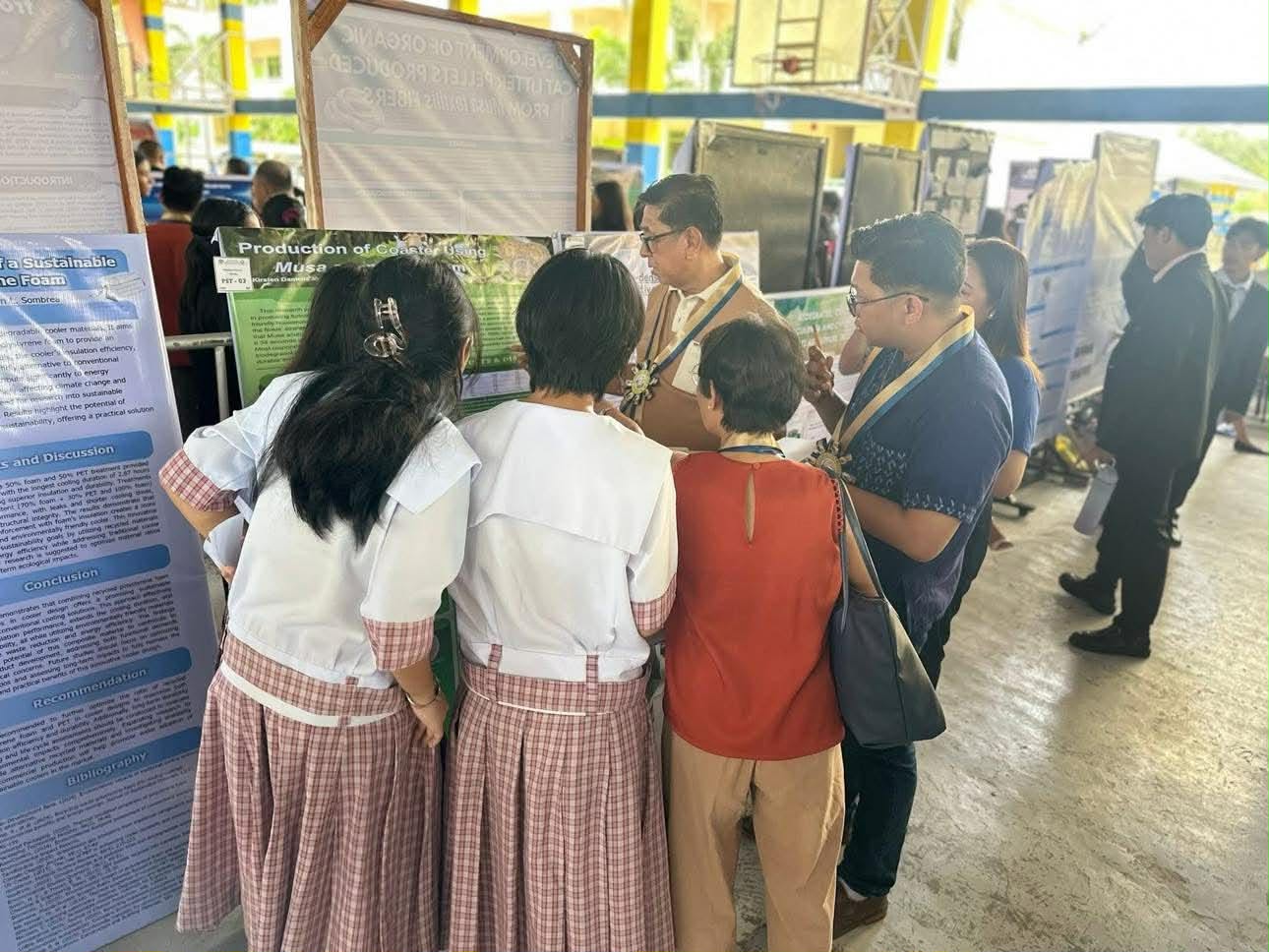 Students and evaluators reviewing research posters
