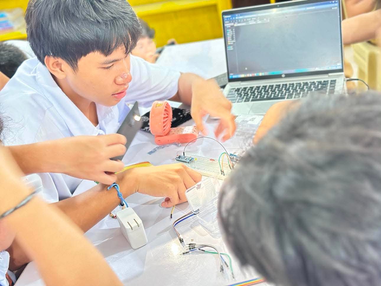 Teacher and students examining projects at an exhibit table