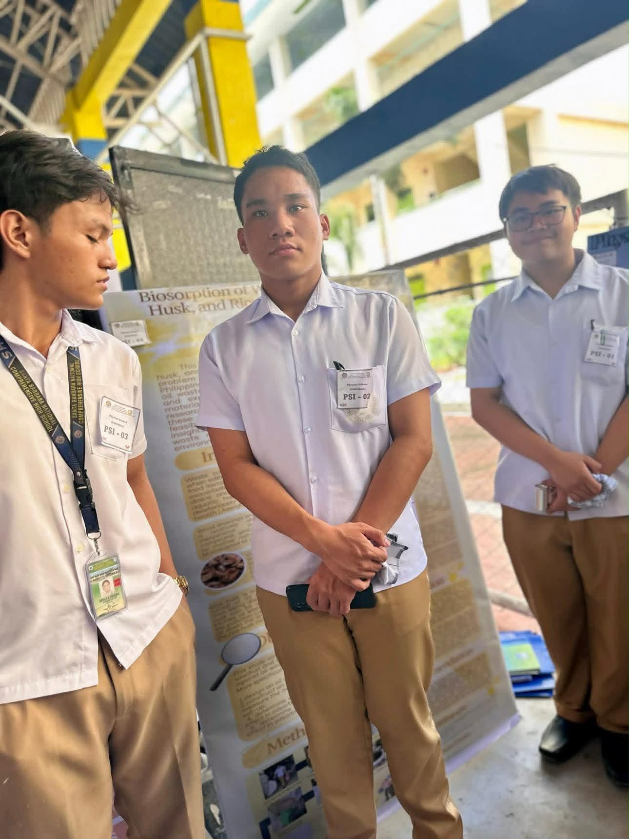 Project adviser standing with student researchers beside their poster