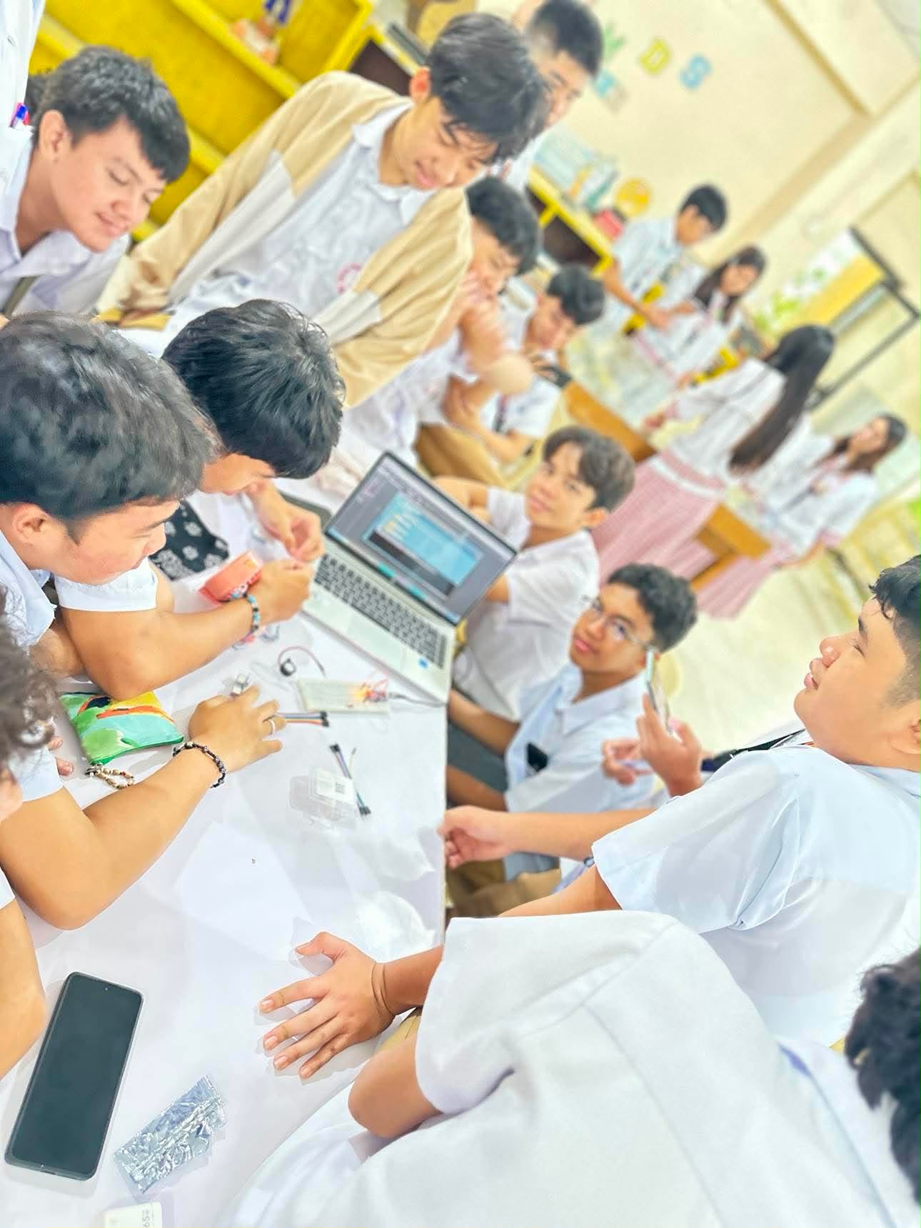 Student research team documenting their project beside a poster